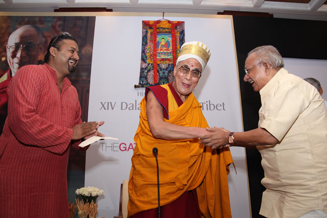 Cartoonist Yesudasan presents a 'Kerala Thalappavu' (headgear) to His Holiness the XIV Dalai Lama of Tibet during a Friends of Tibet private audience at The Gateway Hotel of Taj, Kochi on September 04, 2010.