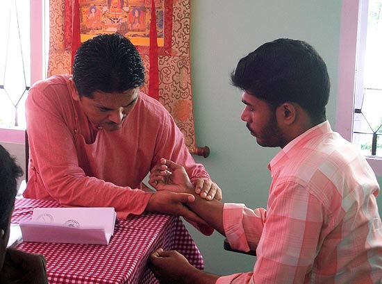 Dr Dorjee Rapten Neshar (CMO, Men-Tsee-Khang) reading the pulse of a patient during the 4th Tibetan Medical Camp at Renewal Centre, Kochi (Photos: Friends of Tibet)