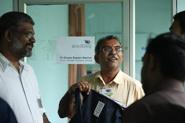 Photograph of Rajsankar with Sethu Das, Sreejith Saseendran, Appu John and other Volunteers planning the rest of the camp and preparing Green Health Books for the newly-registered patients of December 2011. Once at the Wellbeing Camp venue Rajsankar needs to work with other Wellbeing Volunteers. He needs to verify the bookings and reports cancellations. He also needs to ensure that the entire team gets their consultation time with the doctors according to their booking preferences.