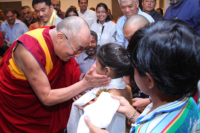 His Holiness the XIV Dalai Lama of Tibet blesses Swaroopa Nirmal and Kelvin Eldho during the Friends of Tibet meet in Kochi, Kerala. His Holiness was in Kochi to address a gathering of 'Friends of Tibet' members and 'Wellbeing' beneficiaries at the Holiday Inn on November 25, 2012. The Dalai Lama spoke about 'The Art of Happiness' at this event organised by the 'Friends of Tibet Foundation for the Wellbeing'.