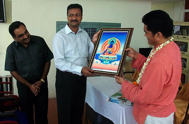 Dr Dorjee Rapten Neshar of Men-Tsee-Khang presents a 'Blue Buddha' painting to Dr C Manoj Kumar, Chief Physician of Nagarjuna Ayurvedic Centre at Okkal, Kalady, Kerala on January 22, 2011