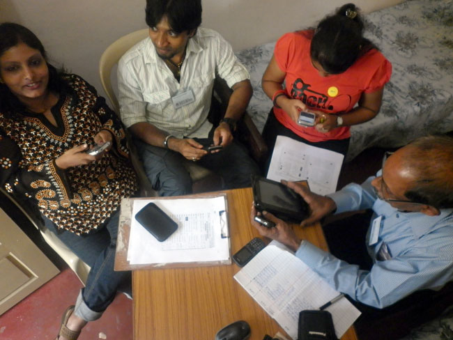 Rashmi Sidharthan, Nirmal Antony, Samta Shah and Suresh Babu of Friends of Tibet Wellbeing programme test the newly-developed version of Wellbeing Mobile App by ThoughtShastra on various mobile devises during the 26th Wellbeing camp held at Kochi from February 27-March 2, 2013. (Photo: Friends of Tibet)