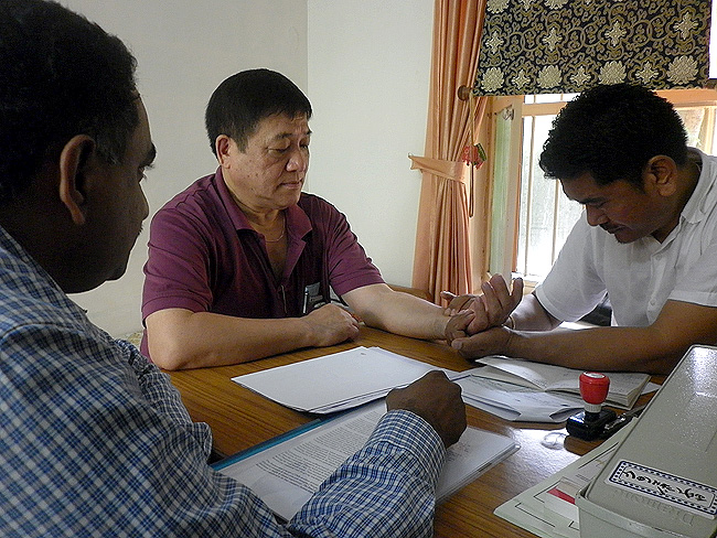 CL Denzongpa (DGIT: Investigations) consults Dr Dorjee Rapten Neshar during the 27th Wellbeing Tibetan Camp at Kochi, Kerala organised by Friends of Tibet and Men-Tsee-Khang. Dr Madhavachandran (R&D, Nagarjuna Ayurveda) next to them. (Photo: Friends of Tibet)