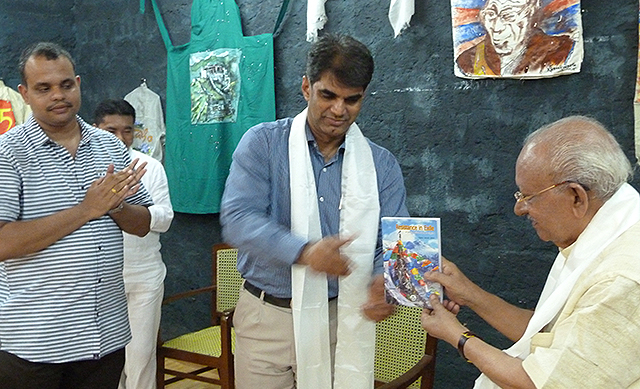 Dr KN Raghavan releases the book 'Resistance in Exile: A Study of Tibetan Poetry in English' written by Dr Appu Jacob John by giving a copy to Cartoonist Yesudasan.
