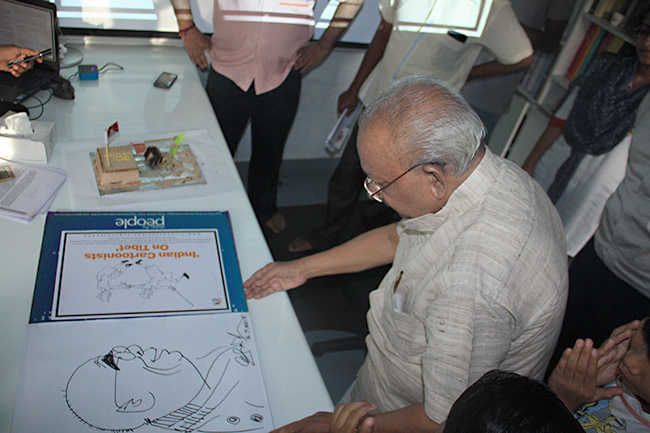 Political cartoonist Shri Yesudasan launching 'Indian Cartoonists on Tibet' Book Project by drawing a caricature of His Holiness the XIV Dalai Lama.