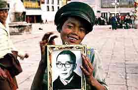 tibetan boy with photo of dalai lama