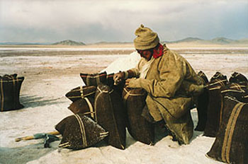 Tibetan on salt flats, with big bags of salt