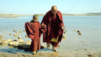His Holiness the Dalai Lama and a young monk wading at the seaside